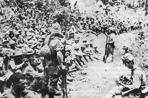 Japanese soldiers guard American and Filipino prisoners of war after the conclusion of the Battle of Bataan