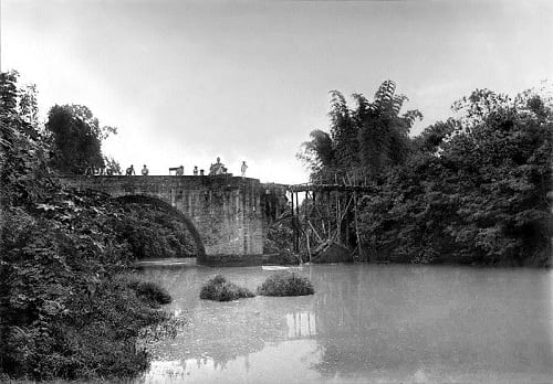The Bridge of Isabel II in 1899 with the missing northern span blown up by the revolutionaries, temporarily replaced by a wooden plank